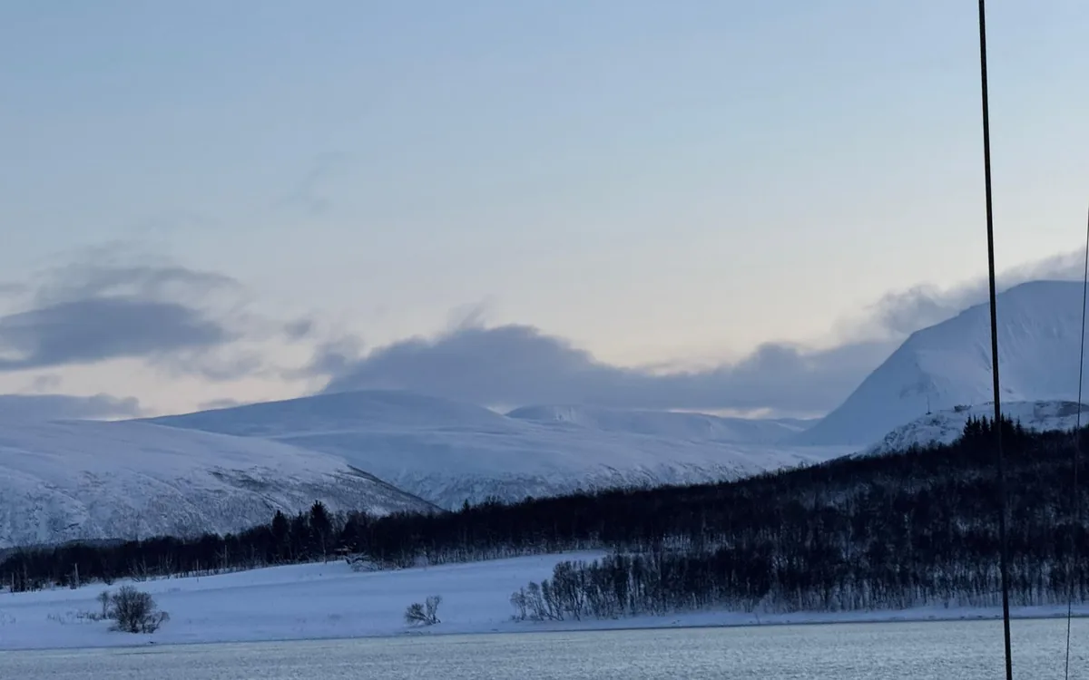 A winter fjord near Tromso with snow-covered peaks above the water