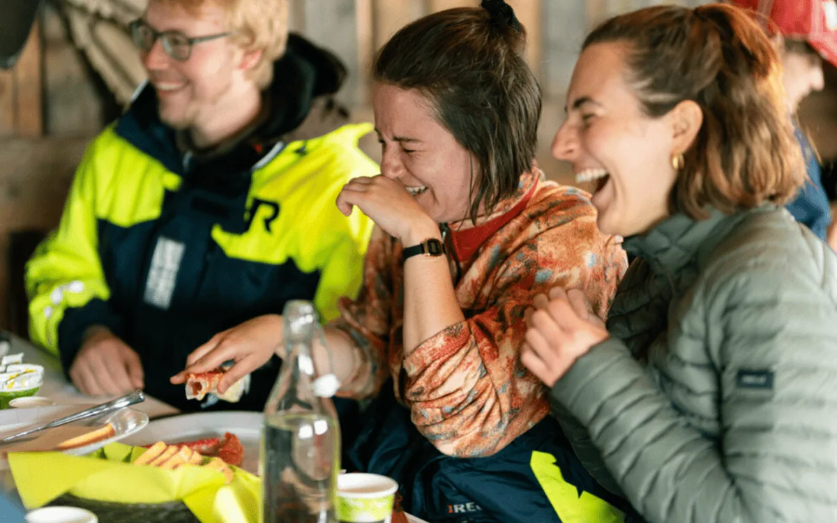 Guests laughing around a table of freshly cooked king crab